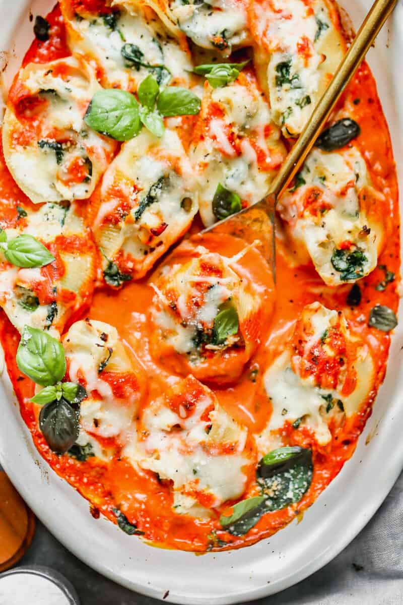 chicken stuffed shells with spinach in white baking dish