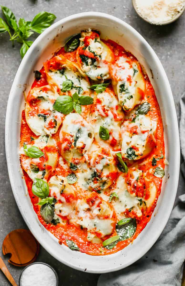 stuffed shells with chicken and spinach garnished with basil