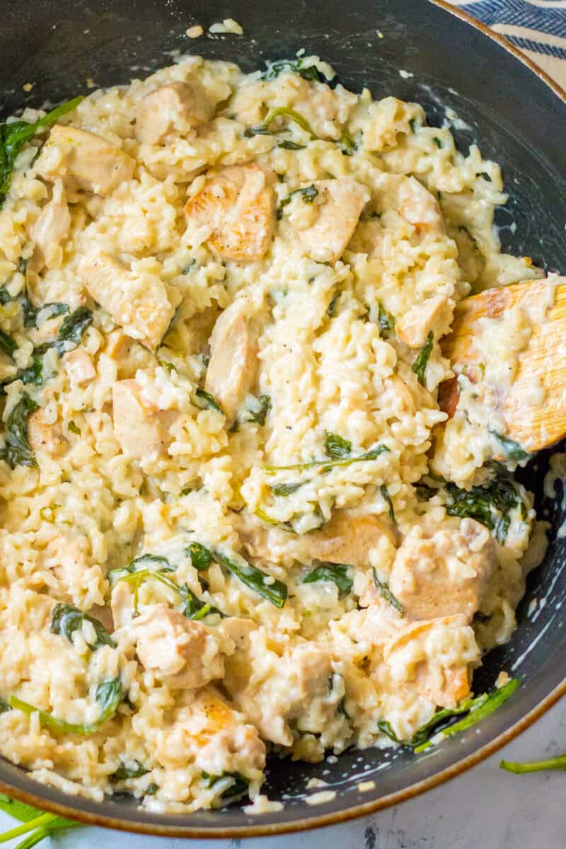 garlic chicken and rice in pot with wooden spoon