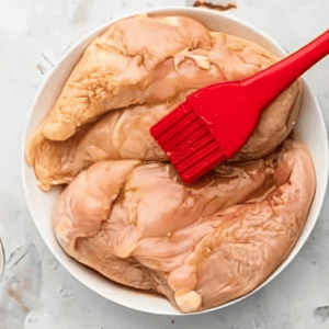 brushing chicken breasts with syrup.