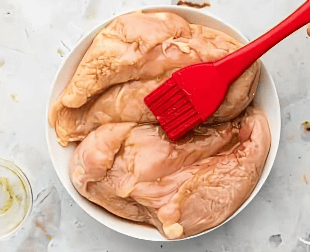 brushing chicken breasts with syrup.