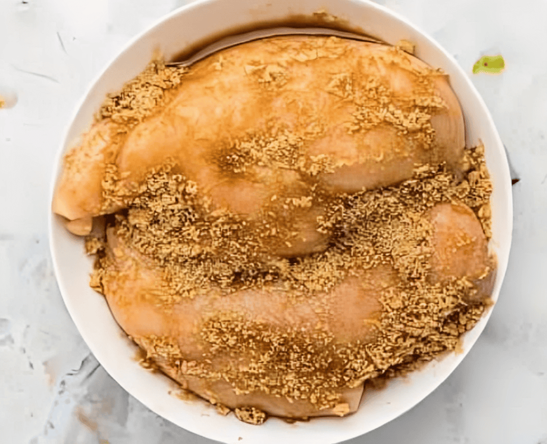 chicken breasts coated in a brown sugar spice mixture in a white bowl.