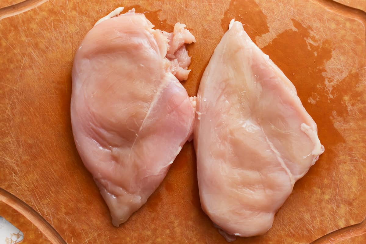 raw chicken breasts on a cutting board.