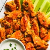buffalo wings on white platter with dip