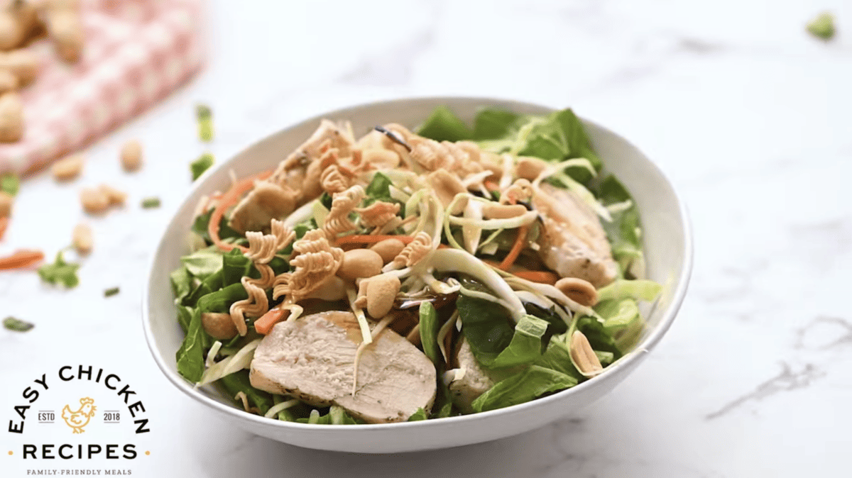 A white bowl is filled with chinese chicken salad. 