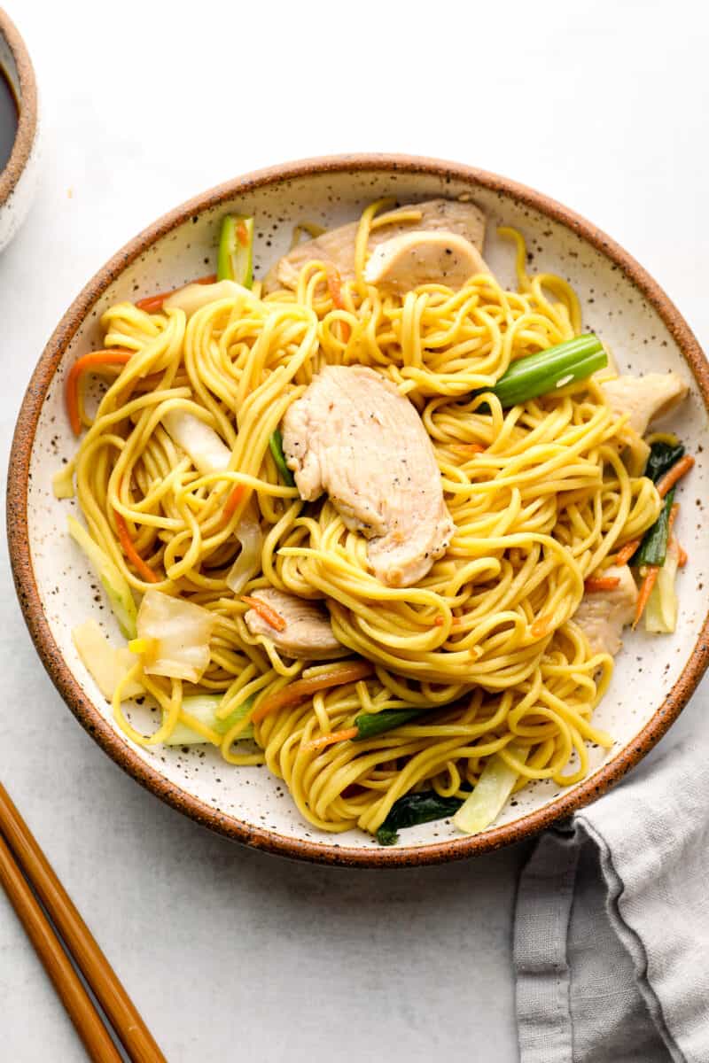 white plate with chicken chow mein noodles