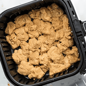 coated raw chicken nuggets in an air fryer.