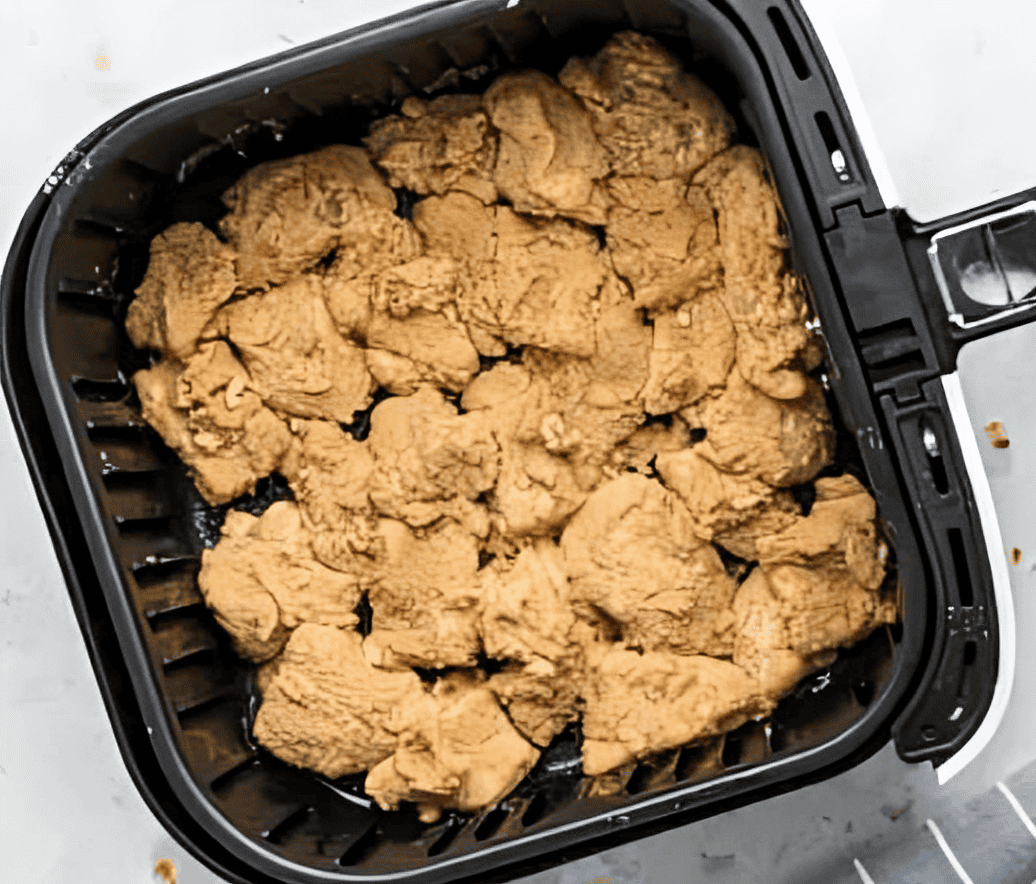 coated raw chicken nuggets in an air fryer.