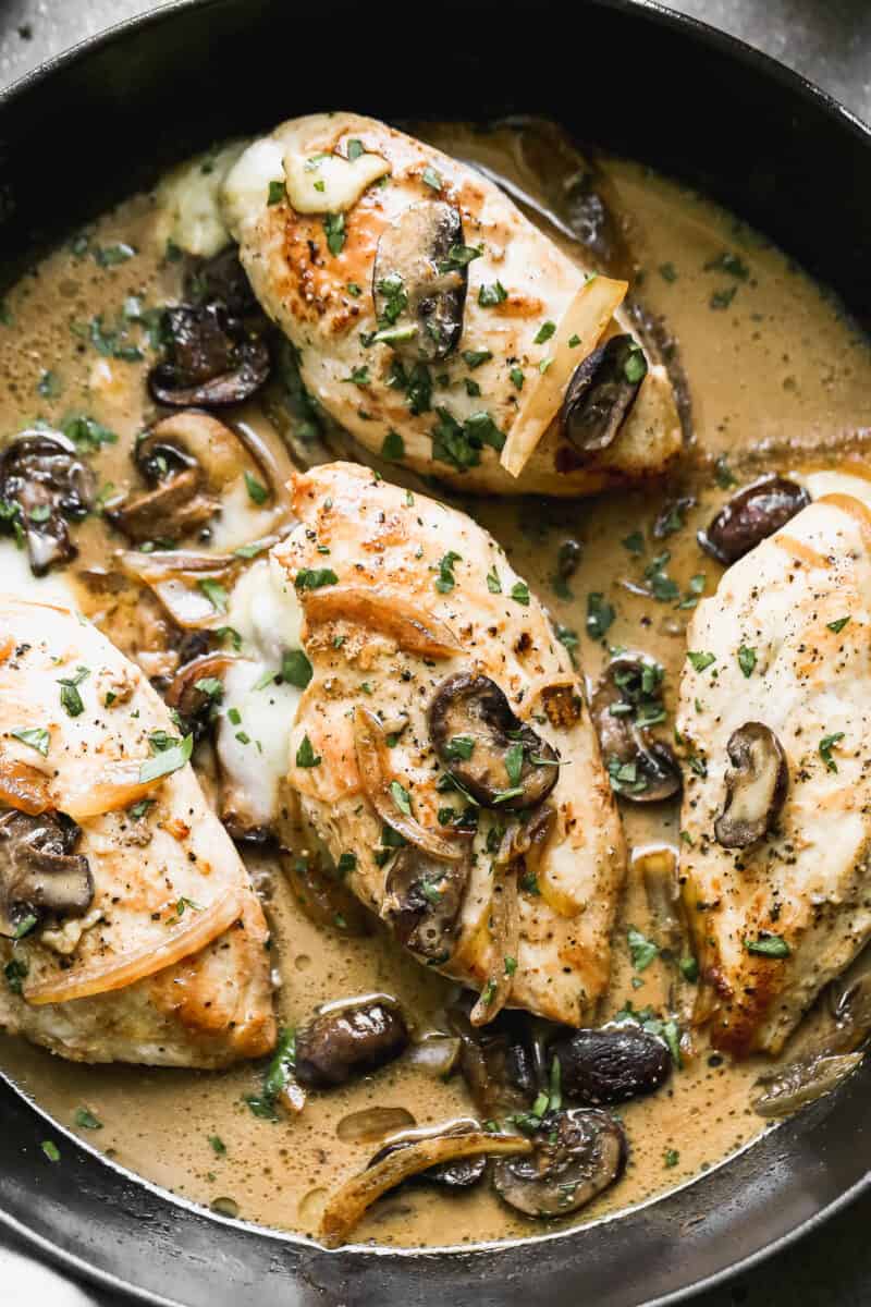 Skillet with sauce and marsala stuffed chicken.