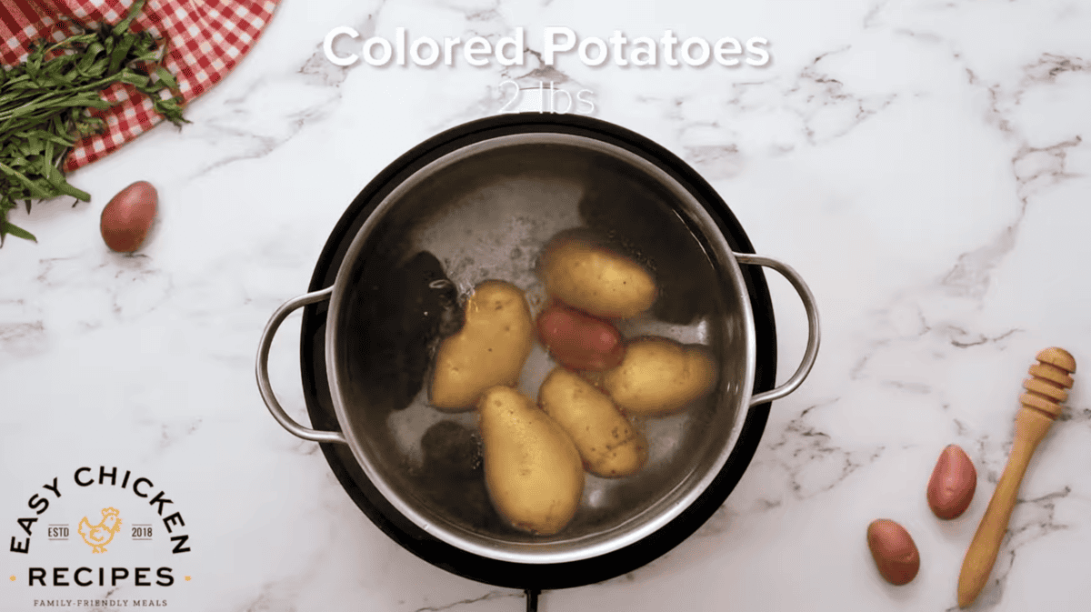 Potatoes are being par boiled in a pot. 