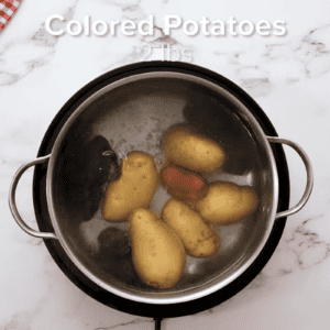 Potatoes are being par boiled in a pot.