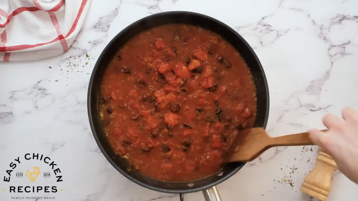 Tomato sauce is cooking in a skillet. 