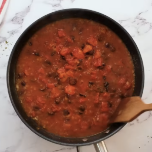 Tomato sauce is cooking in a skillet.