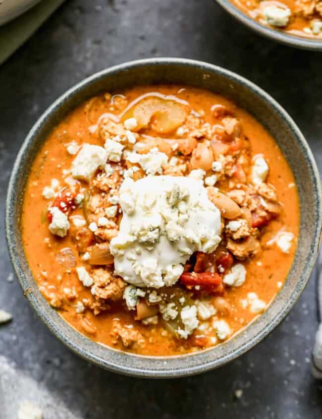 buffalo chicken chili in gray bowl topped with blue cheese