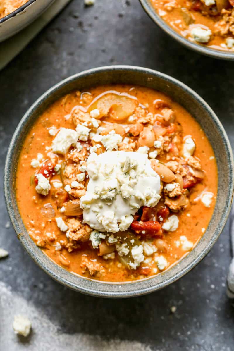 buffalo chicken chili in gray bowl topped with blue cheese