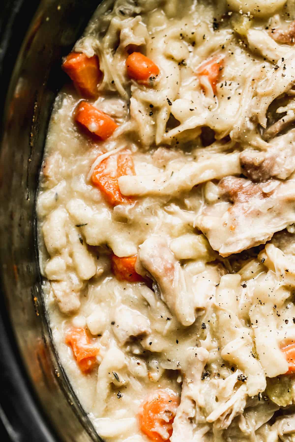 Close up chicken and egg noodles in a slow cooker.