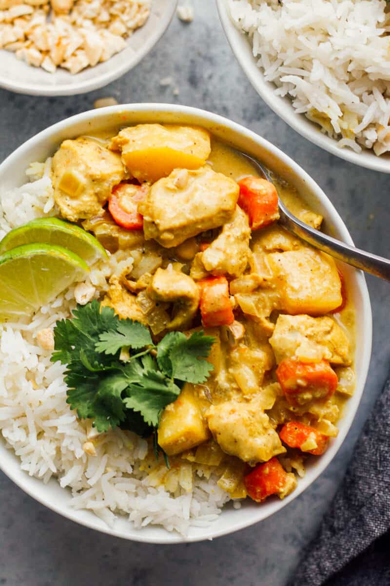 crockpot yellow chicken curry with rice in white bowl