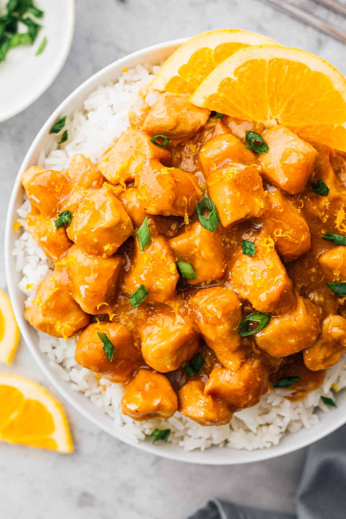 A bowl of slow cooker orange chicken with white rice.
