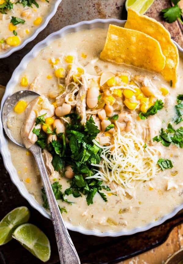 overhead view of a bowl of crockpot white chicken enchilada soup with a spoon.