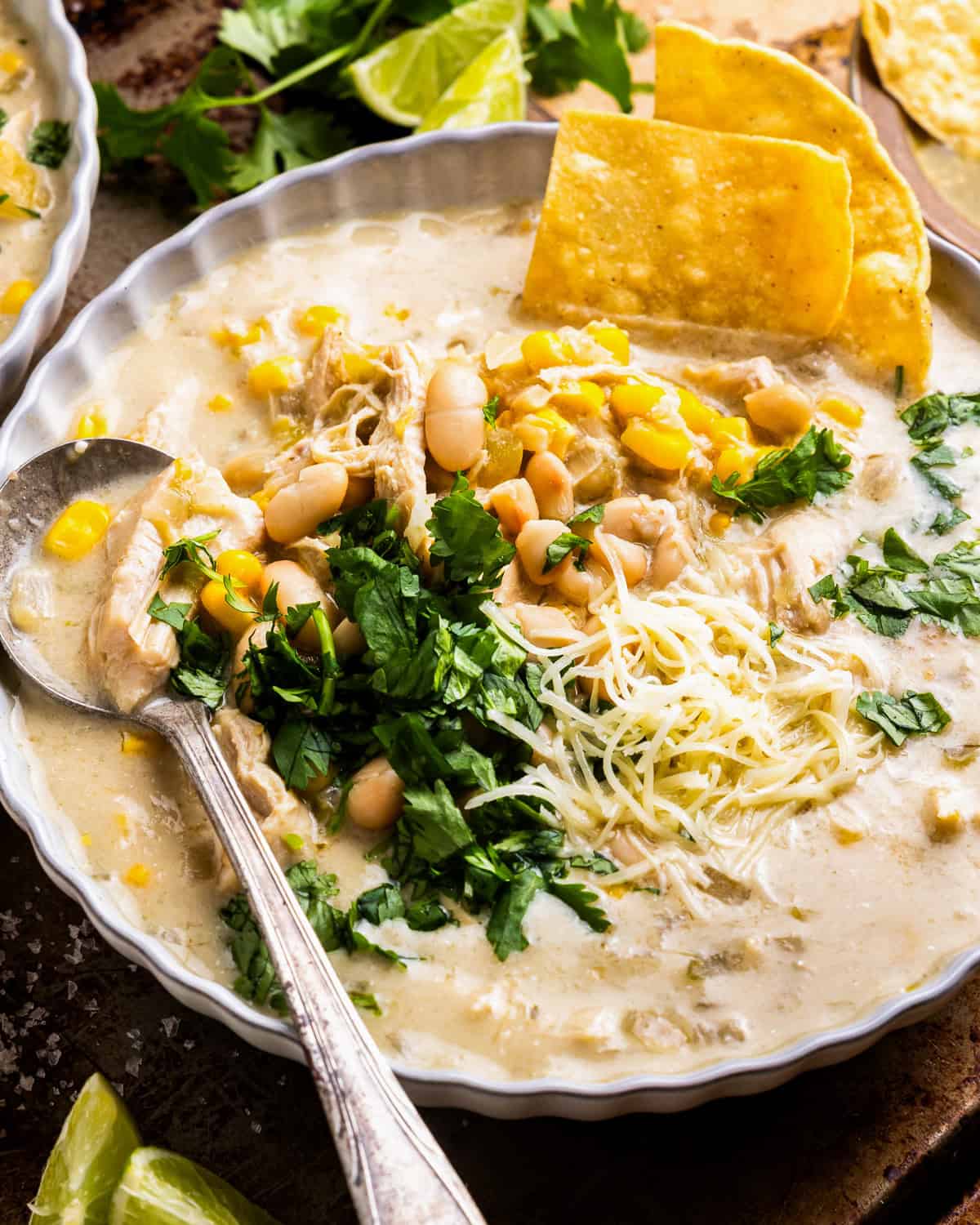 a bowl of crockpot white chicken enchilada soup with a spoon.