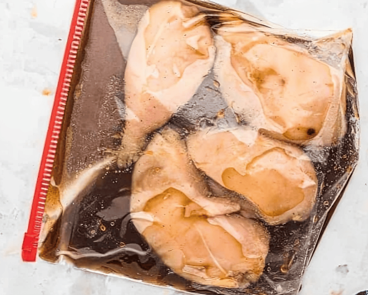 chicken breasts in bourbon marinade in a Ziplock bag.