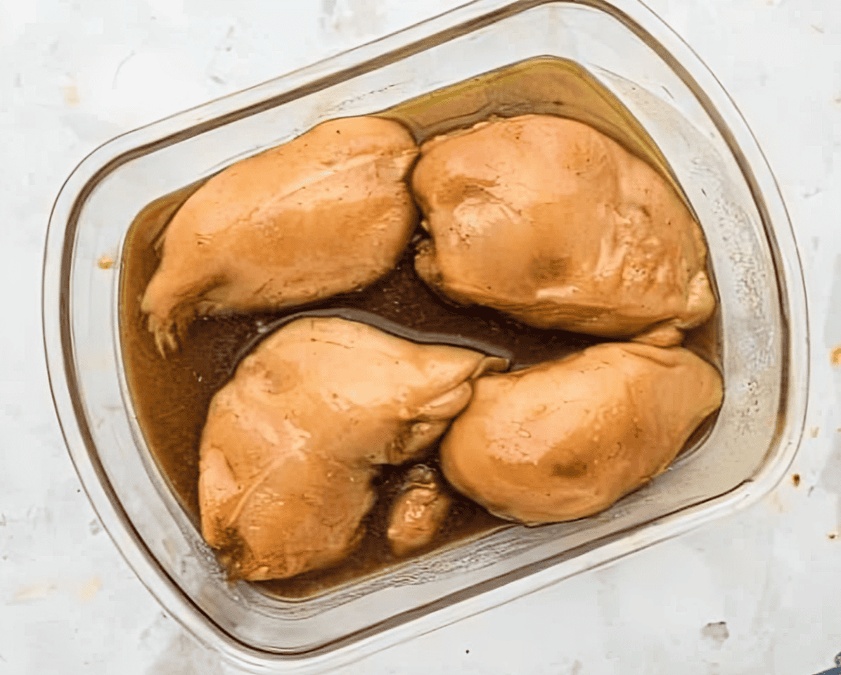 maple bourbon marinated chicken breasts in a glass baking dish.