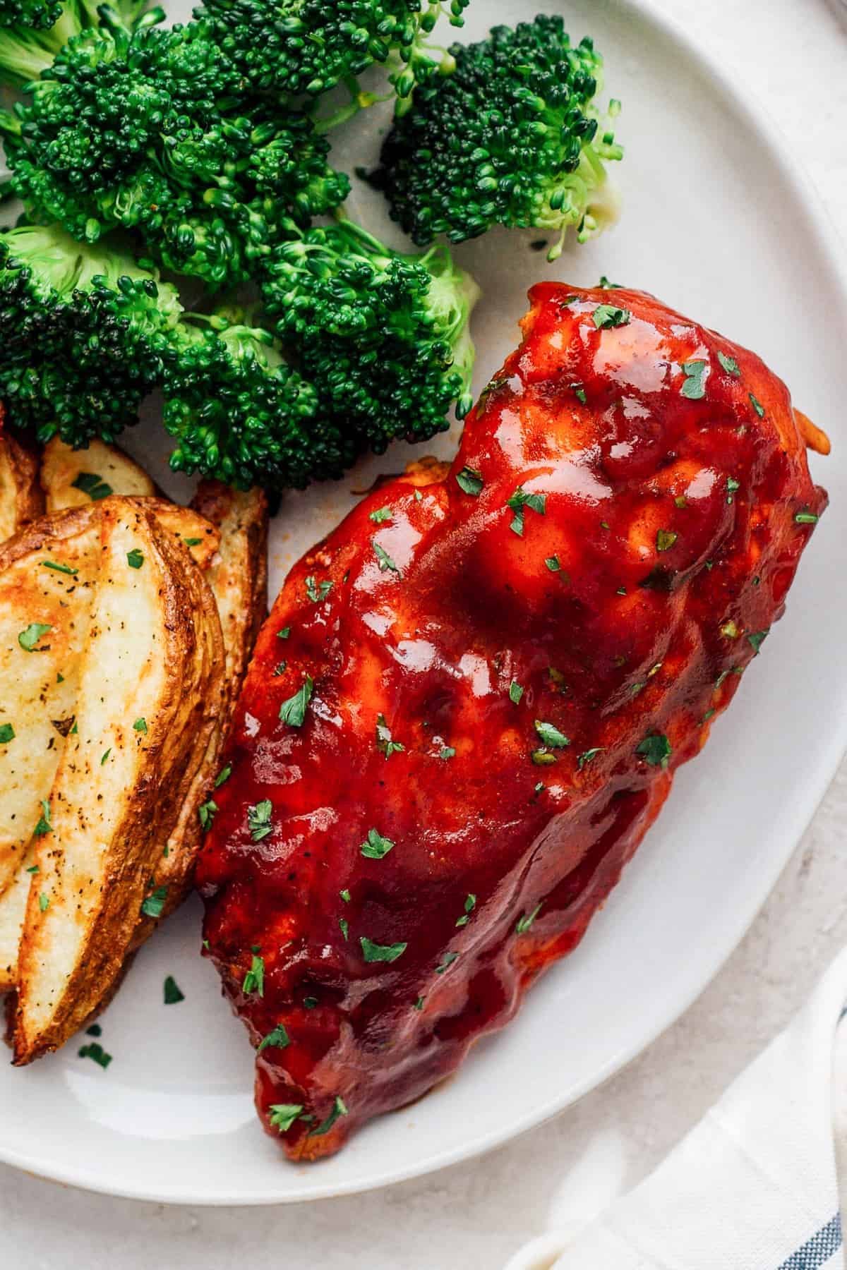 instant pot bbq chicken breast on plate with broccoli and potato wedges