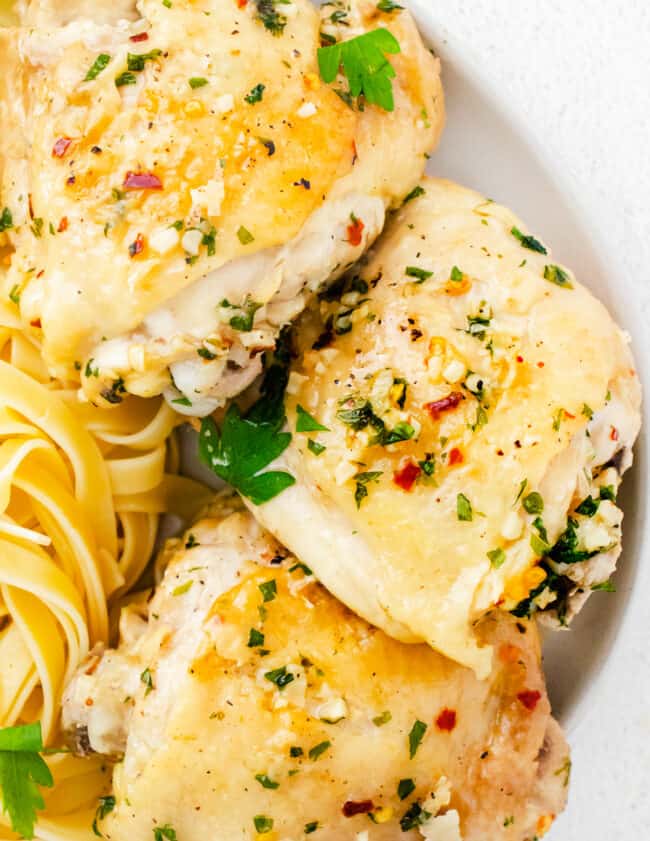 garlic parmesan chicken thighs on plate with pasta