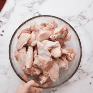 Instant Pot chicken wings in a bowl on a marble countertop.