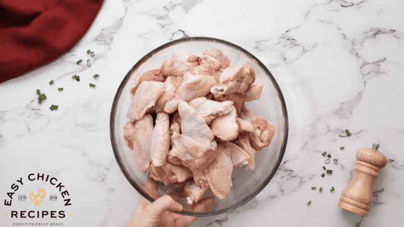 Instant Pot chicken wings in a bowl on a marble countertop.