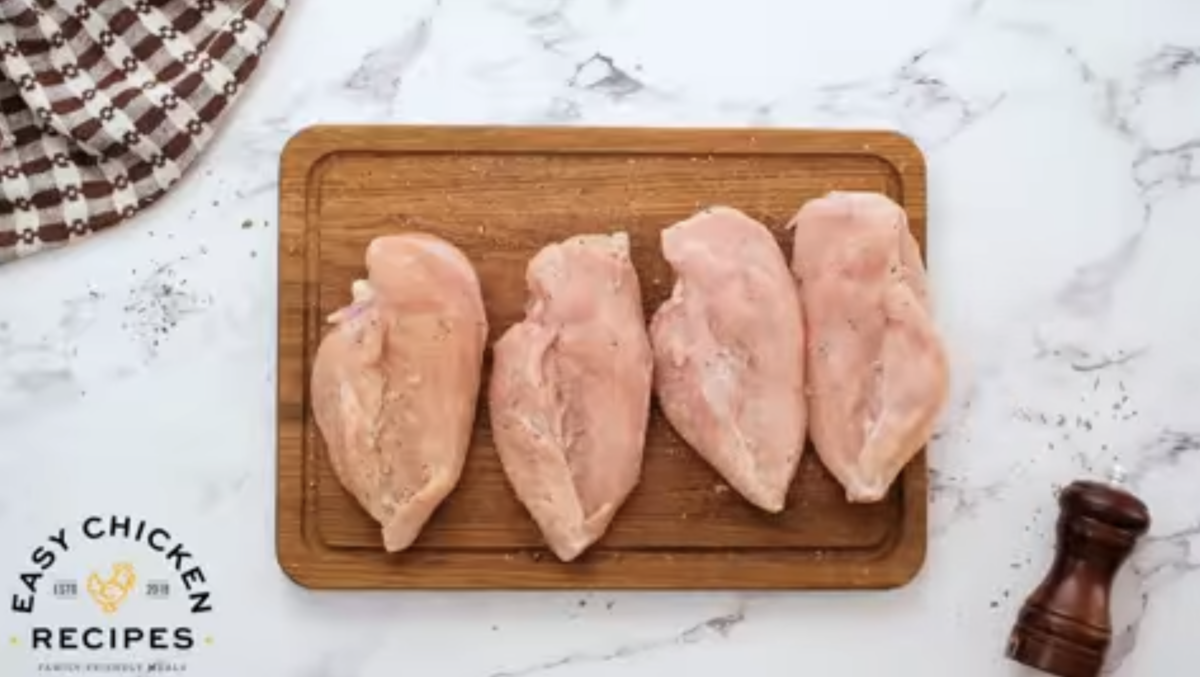 Raw chicken breasts are seasoned. 