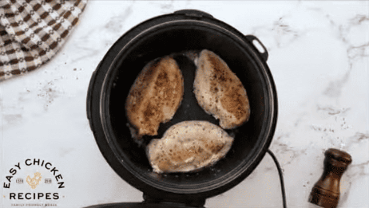 Chicken breasts are being seared in an instant pot. 