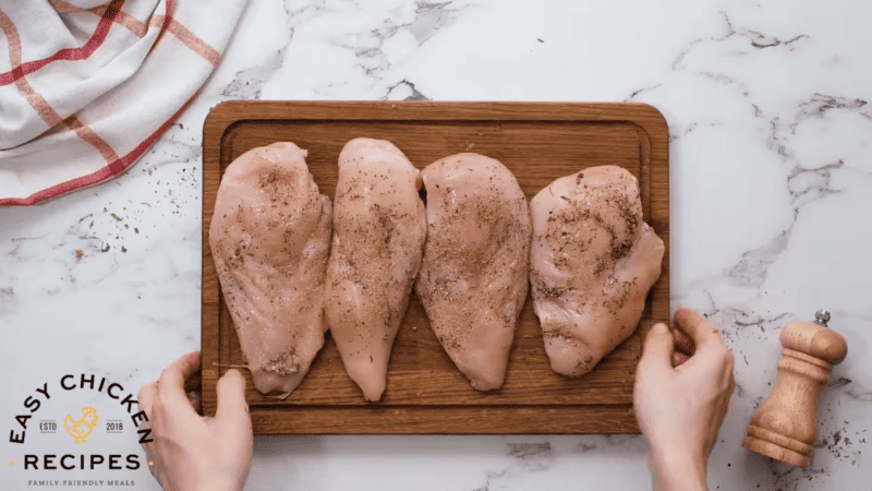 Four chicken breasts ready for Instant Pot shredding, placed on a wooden cutting board.