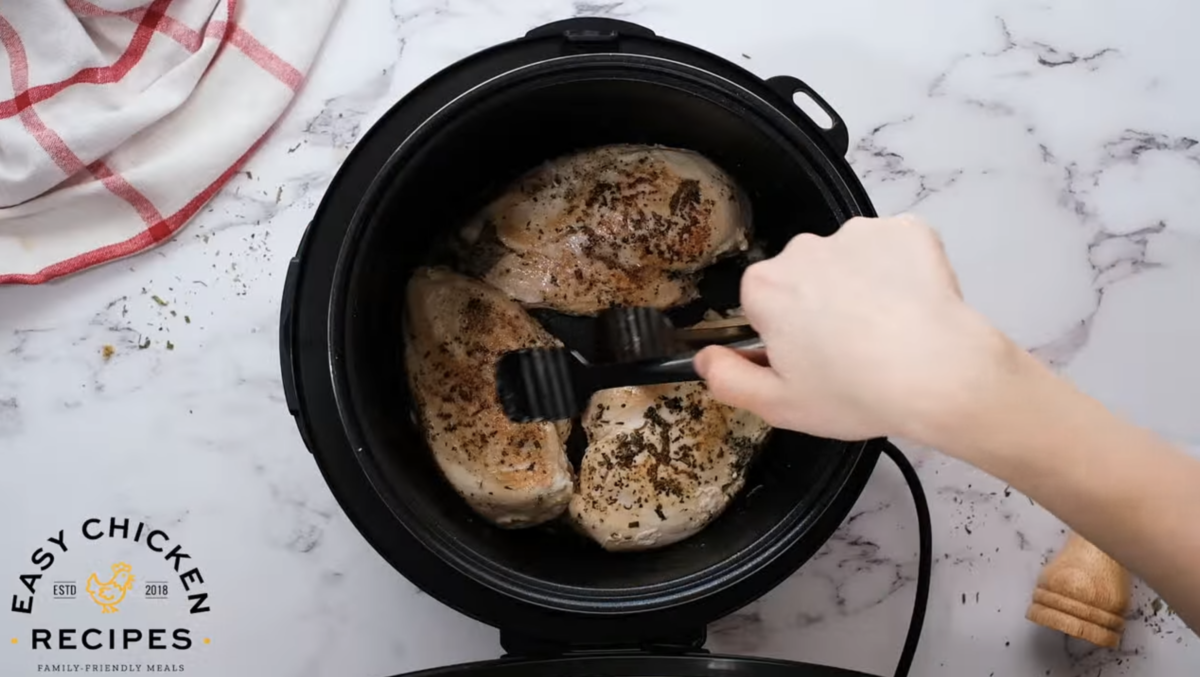 Chicken breasts are being seared in the pressure cooker. 