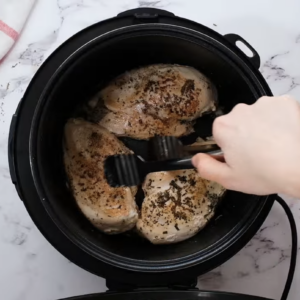 Chicken breasts are being seared in the pressure cooker.