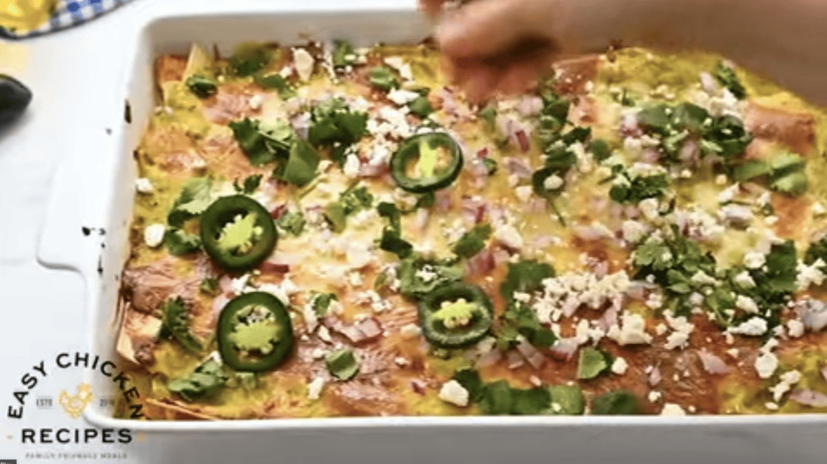 A baked chicken casserole is topped with garnishes. 