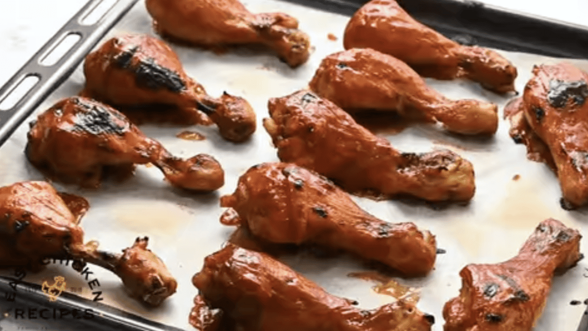 Chicken drumsticks are coated in bbq sauce.