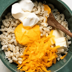 Stirring butter, cream cheese, and cheese into macaroni.