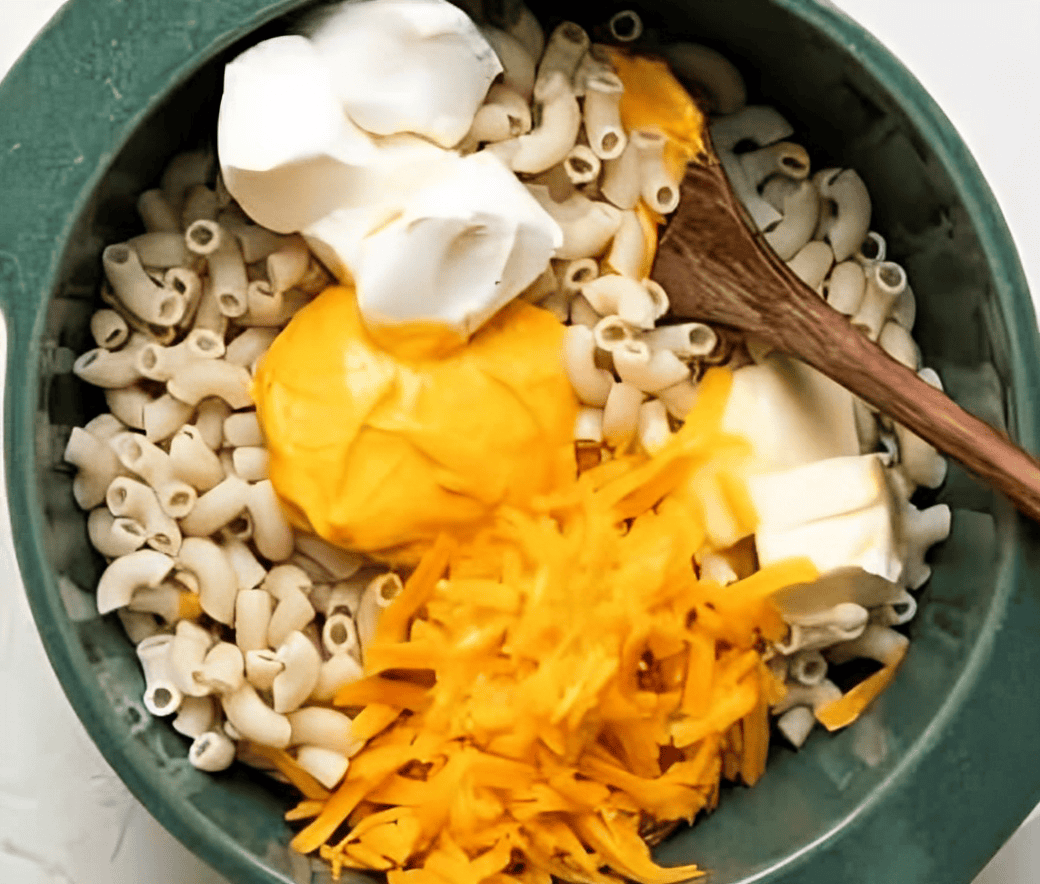 Stirring butter, cream cheese, and cheese into macaroni.