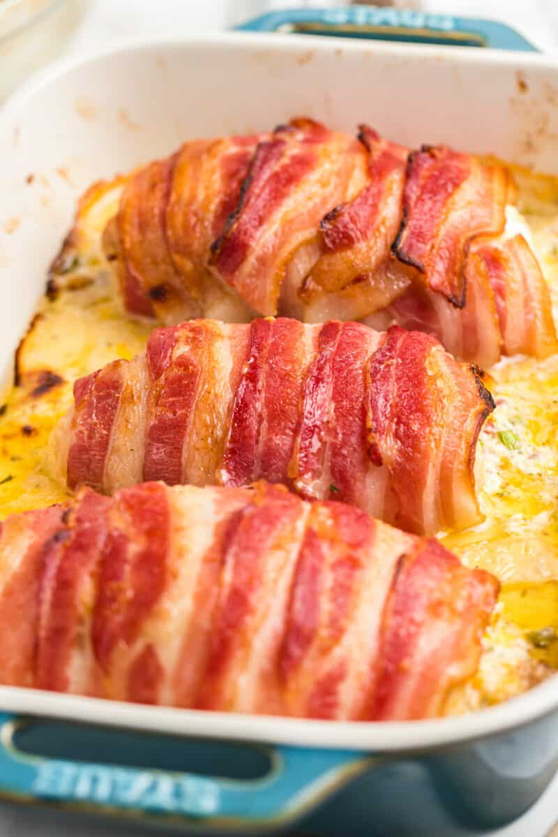 bacon wrapped stuffed chicken in baking dish