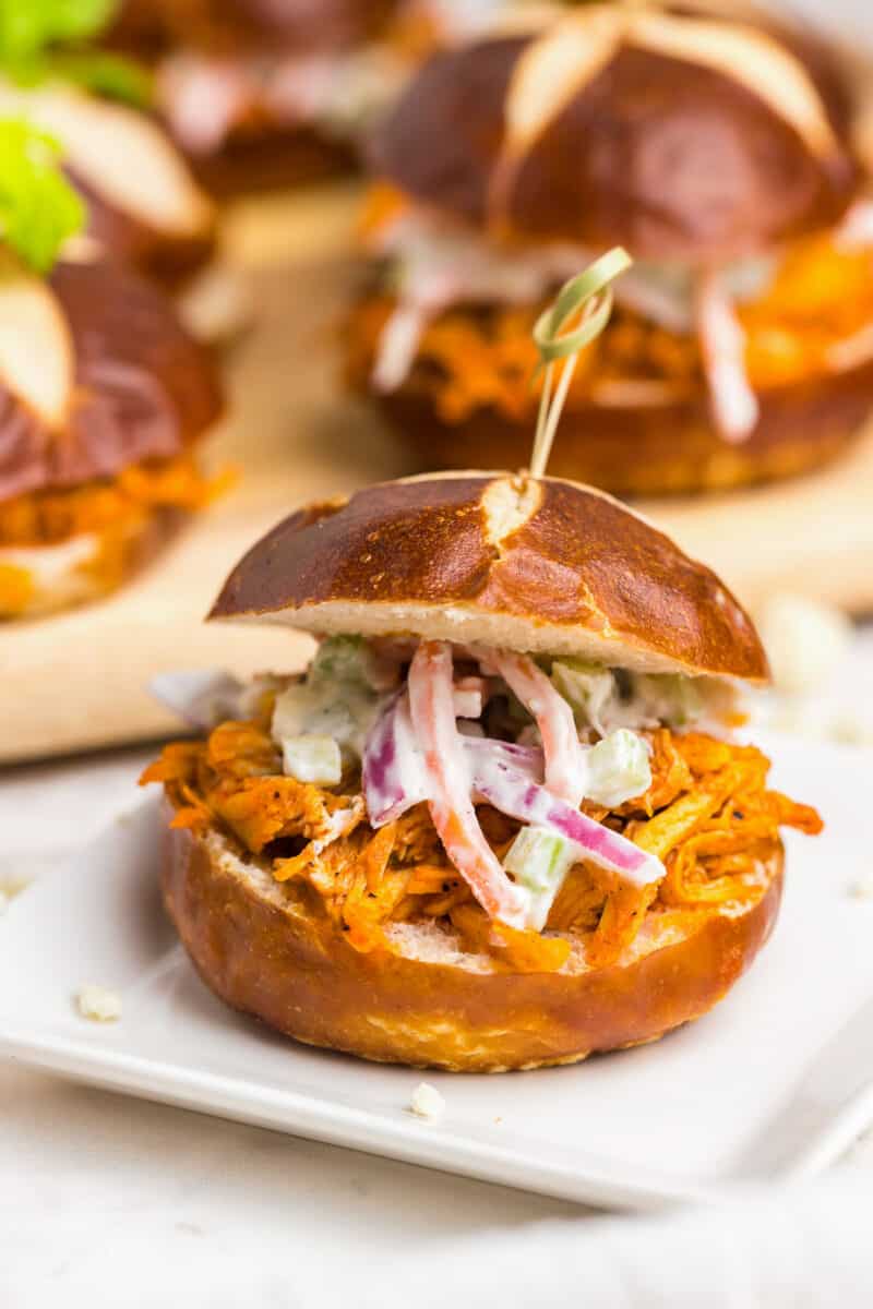 many baked buffalo chicken sliders on table