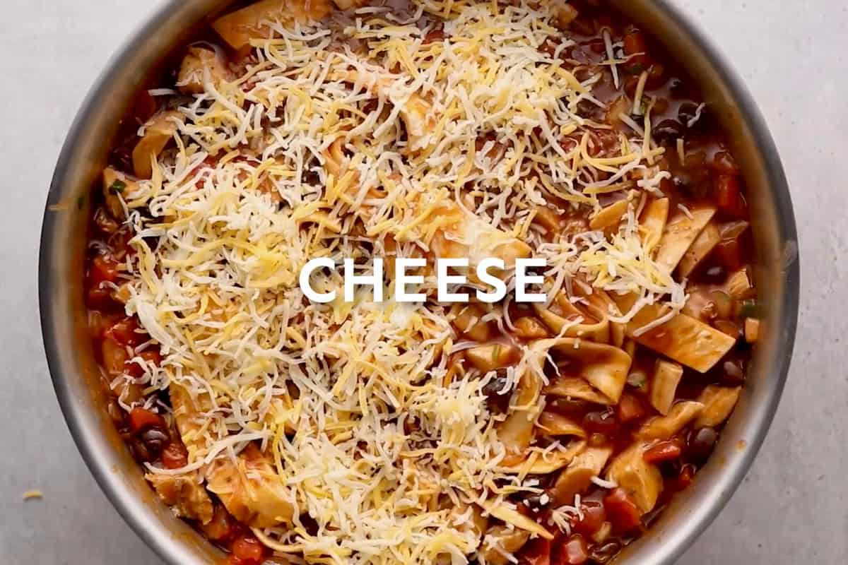 sprinkled cheese over chicken enchilada skillet with text "CHEESE" overlayed.