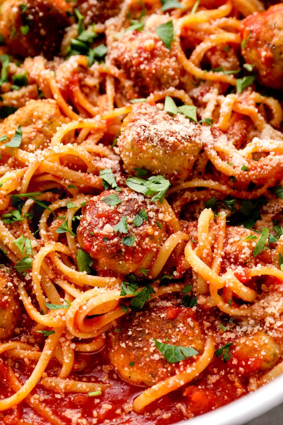 Up close view of spaghetti with red tomato sauce and chicken meatballs.