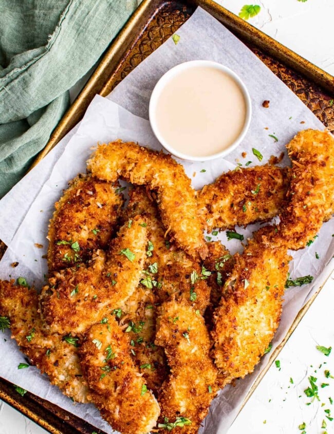 crispy baked coconut chicken tenders on parchment