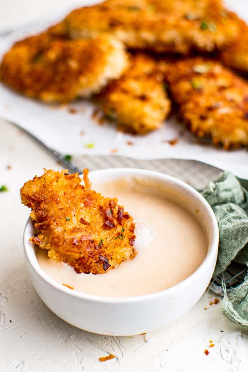 dipping coconut chicken tender in pina colada dip