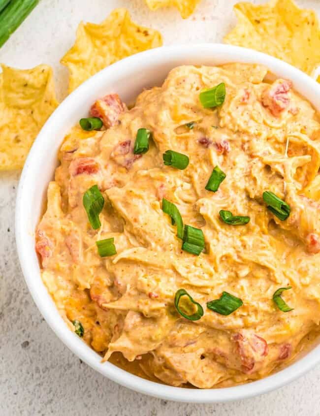 white bowl of crockpot queso chicken with chips