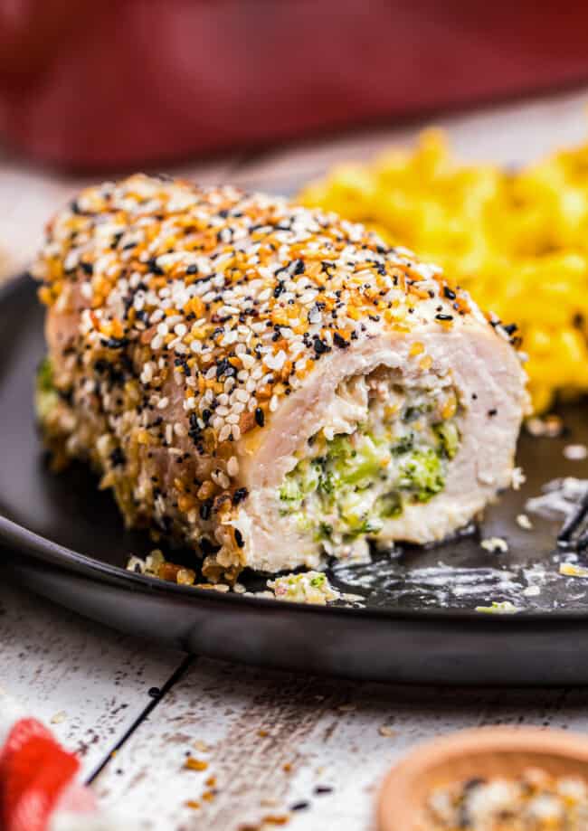 everything stuffed chicken breast on black plate filled with broccoli and cheese
