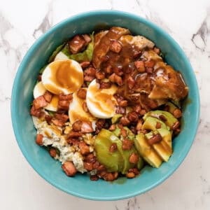 balsamic dressed chicken cobb salad in a blue bowl.