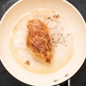 a seared chicken breast in a pan.