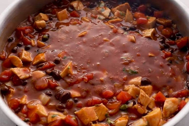 Chicken enchilada casserole cooking in a skillet.